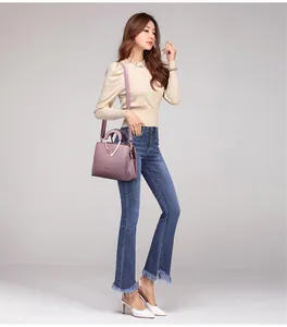 Elegante lavendelblaue Damen-Handtasche mit V-förmigem Metallakzent und Umhängeriemen.
