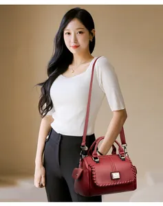 Elegant red textured leather shoulder bag featuring braided details and adjustable strap