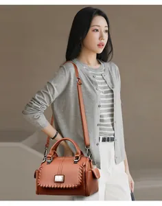 Elegant brown textured leather handbag for women, crossbody style shown on model.