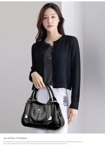 Close-up view of a fashionable black pebbled leather handbag with triple pockets
