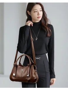 Detailed view of an elegant brown pebbled leather handbag with a kangaroo emblem.