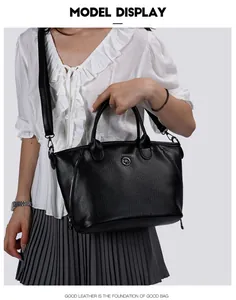 Elegant black faux leather handbag with textured finish shown on a female model