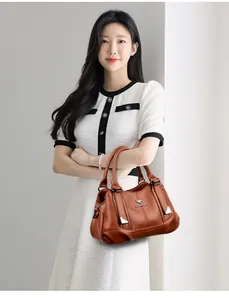 Elegant brown soft leather handbag held by a model with a clean white background