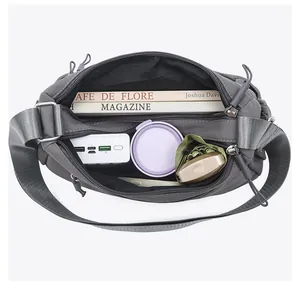 Top view showing the large capacity interior of the grey crossbody bag with items.