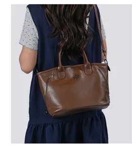 Back view of brown retro leather tote bag with grainy texture and shoulder strap