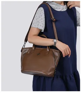 Detail of a vintage brown textured leather handbag for women, shown worn by a model