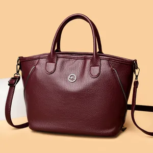 Retro burgundy pebble-grain leather handbag with kangaroo logo and shoulder strap