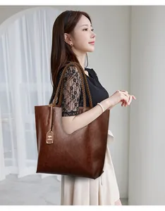 Mujer elegante con un bolso tote grande de cuero marrón con asas trenzadas
