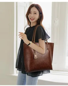 Elegante bolso tote marrón de gran capacidad con asas trenzadas mostrado en modelo