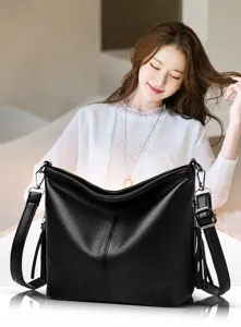 Large black pebbled leather bucket bag with stylish tassels and an adjustable shoulder strap