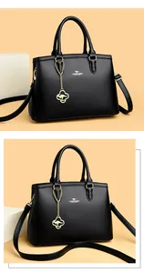 Detailansicht einer schwarzen Lederhandtasche mit elegantem Känguru-Logo-Anhänger