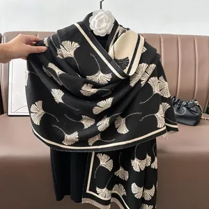 Dettaglio di un pesante scialle con motivo a foglie di ginkgo in tessuto nero e crema