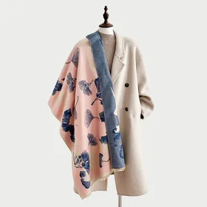 Dettaglio scialle in finto cashmere reversibile con motivi di foglie di ginkgo blu.