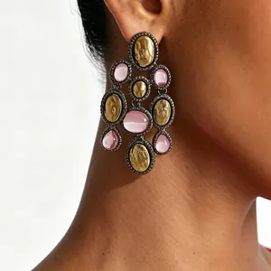 Detail view of vintage boho chandelier earrings with gold hammered metal and pink resin