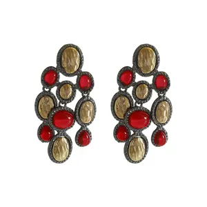 Detailed view of retro ethnic style drop earrings with red resin and gold accents