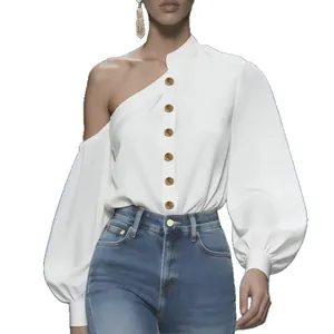 Elegante blusa de satén blanco con un hombro descubierto, manga larga y botones de oro.