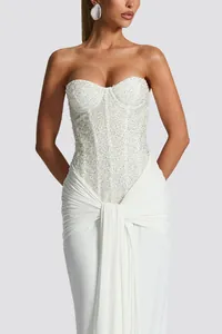Close-up of white strapless dress featuring a beaded corset bodice and draped skirt