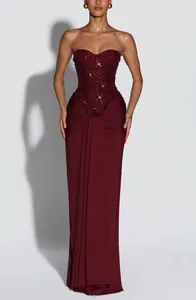 Sophisticated burgundy strapless evening gown featuring a beaded corset and draped skirt