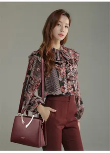 Elegante burgunderrote Handtasche mit V-förmigem Metalldetail für stilbewusste Frauen.