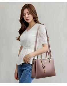 Detail view of an elegant pink leather handbag carried by a model for a chic outfit.