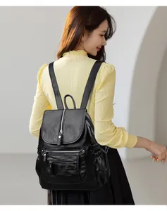 Grand sac à dos vintage en cuir souple noir pour femme porté au dos par un mannequin