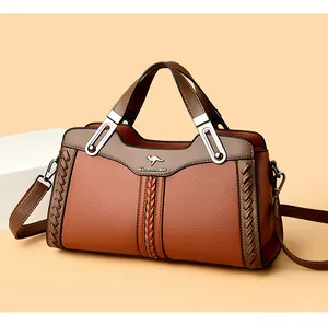 Primo piano di una borsa in pelle marrone con dettagli intrecciati e logo