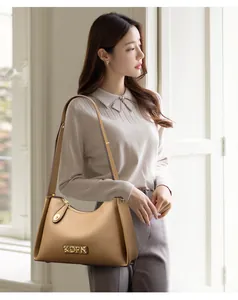Modern khaki leather shoulder bag for women featuring a stylish gold KDFN logo plaque
