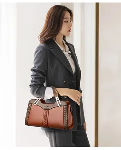 Elegante borsa a mano in pelle marrone da donna con dettagli intrecciati e fibbie in metallo