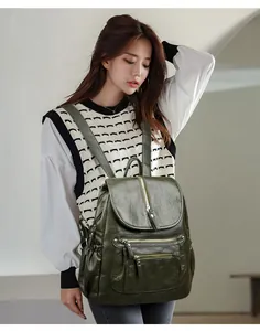 Vue complète d'un sac à dos vintage en cuir vert foncé porté par un mannequin chic