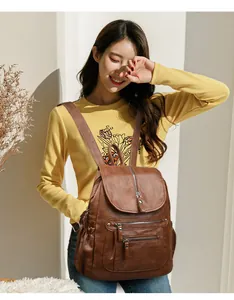 Mannequin asiatique portant un sac à dos vintage en cuir souple marron dans un intérieur