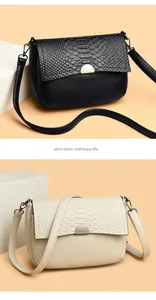 Detail view of crocodile pattern crossbody bags in elegant black and beige finishes.