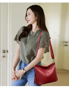 Elegant red leather bucket bag with tassel detail worn by model on shoulder