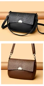 Detail view of fashion crossbody bags in black and brown faux crocodile texture