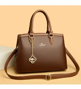 Detail einer eleganten braunen Lederhandtasche mit goldenem Känguru-Anhänger.