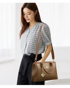Detailansicht einer stilvollen braunen Lederhandtasche an einem Model für einen Look