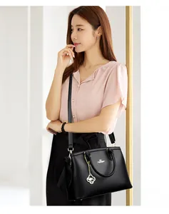 Elegante schwarze Lederhandtasche von asiatischem Model getragen, zeigt Stil.