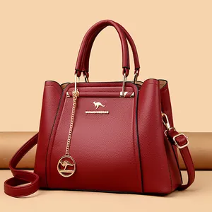 Elegante bolso de mano de cuero sintético burdeos con asas y un colgante dorado