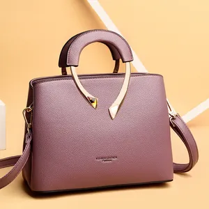 Damen Handtasche aus mauvefarbenem Leder mit markanten goldfarbenen Rundgriffen