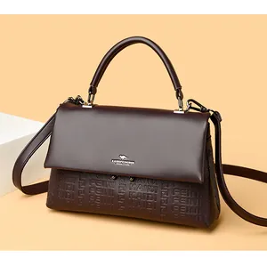 Close-up of elegant brown leather handbag with embossed pattern and top handle