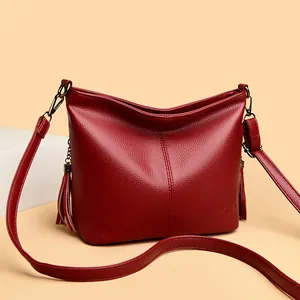 Elegant red faux leather bucket bag with tassels and adjustable shoulder strap for women