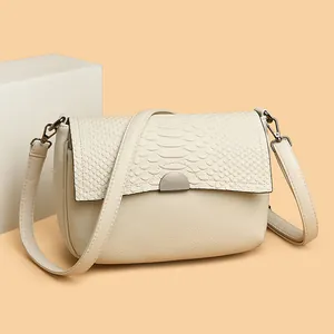 Elegant beige crossbody bag with embossed crocodile texture and metallic clasp hardware.