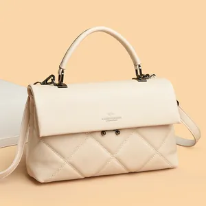 Elegant quilted cream handbag with top handle and crossbody strap