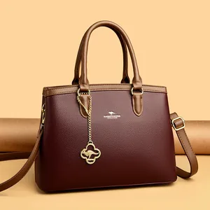 Elegante burgunderrote Damenhandtasche aus Kunstleder mit Kleeblatt-Anhänger und Gurt