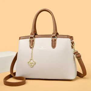 Elegante cremefarbene und braune strukturierte Handtasche mit goldenem Känguru-Anhänger