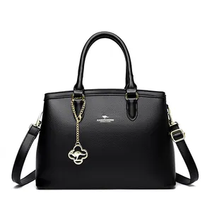 Elegante schwarze Lederhandtasche mit Känguru-Logo und goldenem Taschenanhänger.