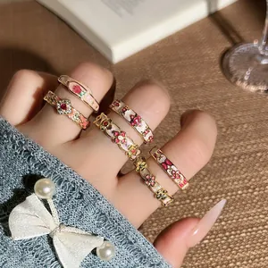 Detailansicht der Vintage-Emaille-Blumenringe mit kunstvollen goldfarbenen Mustern