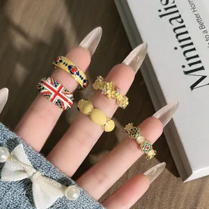 Detail van diverse vintage emaille ringen met Union Jack en bloemen op de hand.