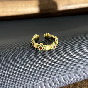 Gedetailleerde close-up van een vintage Britse emaille bloemenring met gouden finish