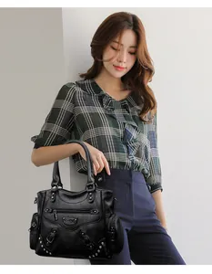 Sac cabas en cuir noir avec rivets porté par un mannequin