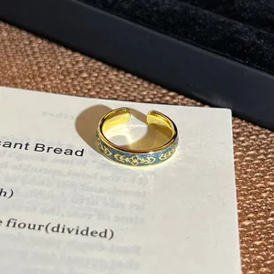 Makroaufnahme eines vergoldeten Vintage-Rings mit blauen Emaille-Blumenmustern.
